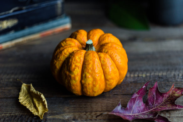 Halloween pumpkin on table with autumn leaves