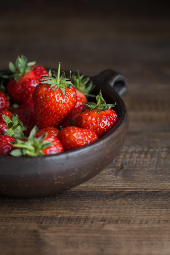 Strawberries in rustic bowl on table